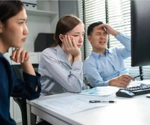 Image of business people stressed out in front of a computer